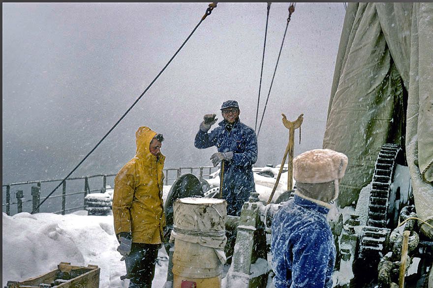 1972-02-038 - 3rd. Engineer Mogens Heine, - dressed in yellow -, - in charge of repairing the windlass in unfavourable weather conditions - (Photography by Karsten Petersen ©)