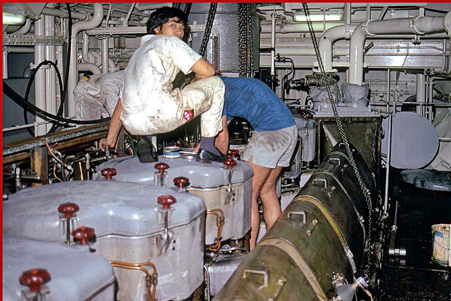 1973-14-096 Chinese 3rd. Engineer Lam, - on top of the engine -, and 2nd. Engineer Per Madsen working on the cylinder head. -  (Photography © Karsten Petersen)