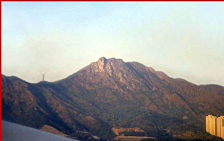 1997-01-045  - Lion Rock - Sz Tsz Shan  Here a spectacular morning view towards the Lion Rock. I took the picture from a plane during landing at Hong Kong's old airport at Kai Tak  -  (Photo- and copyright: Karsten Petersen)