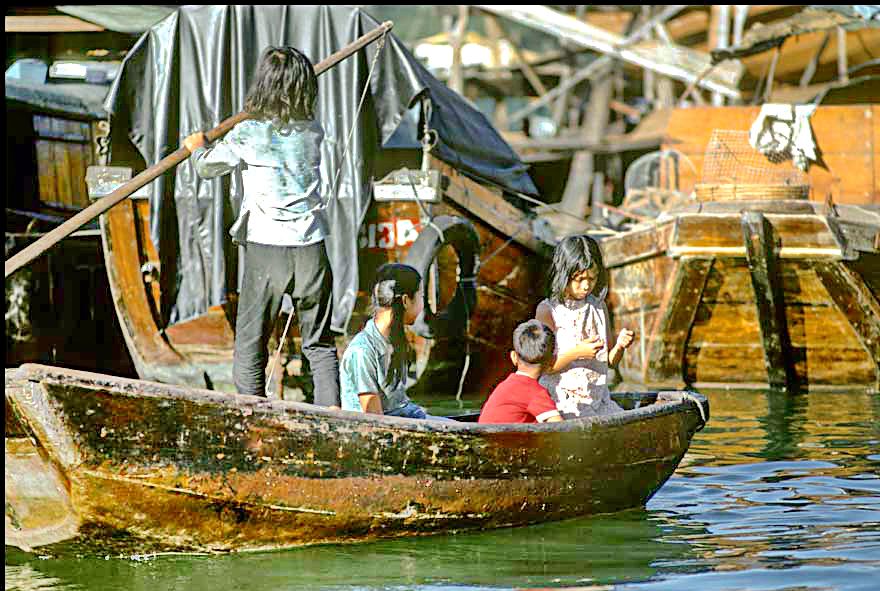1973-04-053  -  Children skilfully navigating a sampan between the anchored junks, Aberdeen Harbour, - autumn 1973  -  (Photo- and copyright: Karsten Petersen)