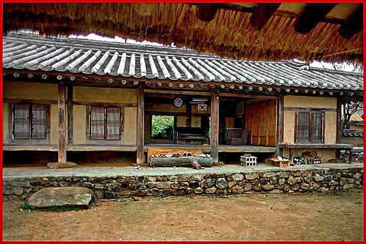 1996-29-087  - Here a closer look at a typical Hahoe house -.  Take note of the shoes left outside!  You take your shoes off - before you enter a house - - Very civilized - -