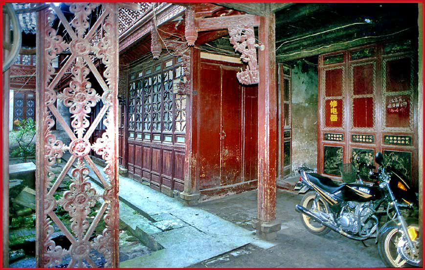 2002-25-100  - Here a contrast between the old wooden wall details - and a modern motor bike - -