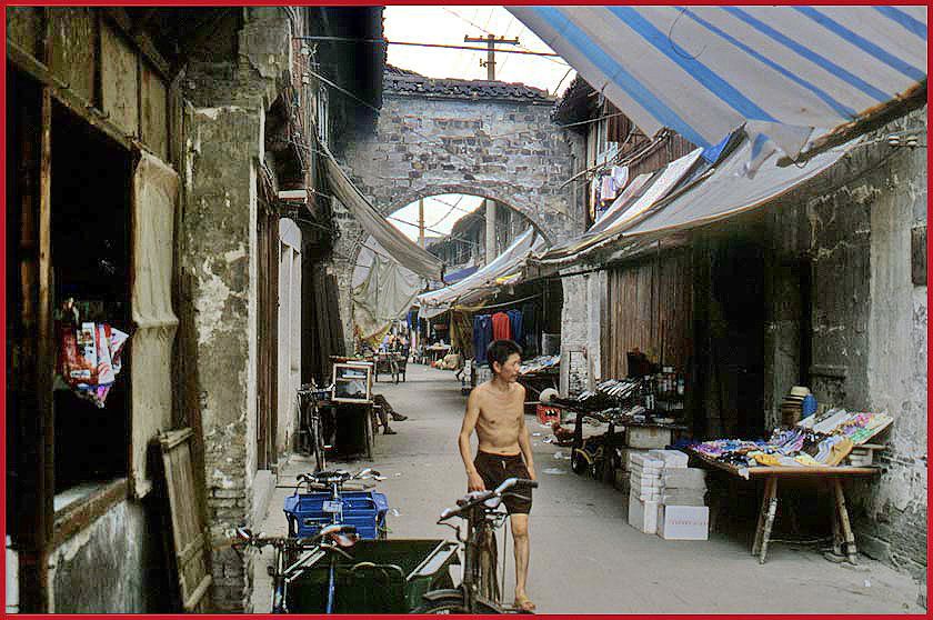 2002-25-V48  - The gate across the road is a passage through a fire-wall.   This kind of fire-wall you can find in many old, Chinese cities - - -