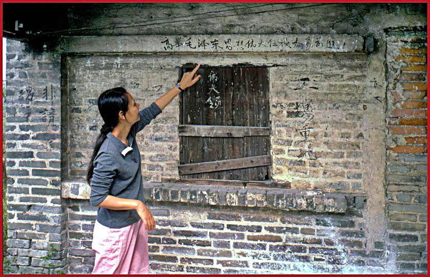 2003-14-012  - Kit Yu showing me an old farm house outside Shen Chun - still with revolutionary Mao quotes on the wall - ((Photo- and Copyright:  Karsten Petersen)