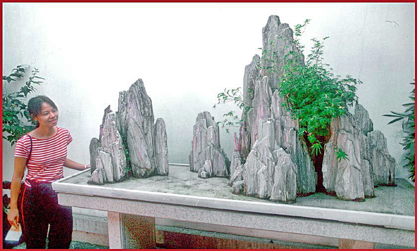 2002-34-V16  - Kit Yu, - and miniature mountains in water, - like rocky islands -, displayed elevated on a table. - we found this beautiful 