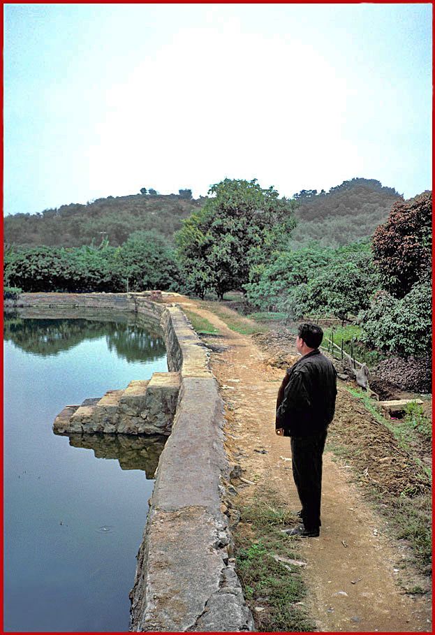 2002-03-021  - Danes Island - fish pond, - our local guide, - and Cemetery Hill behind - (Photo- and copyright: Karsten Petersen)
