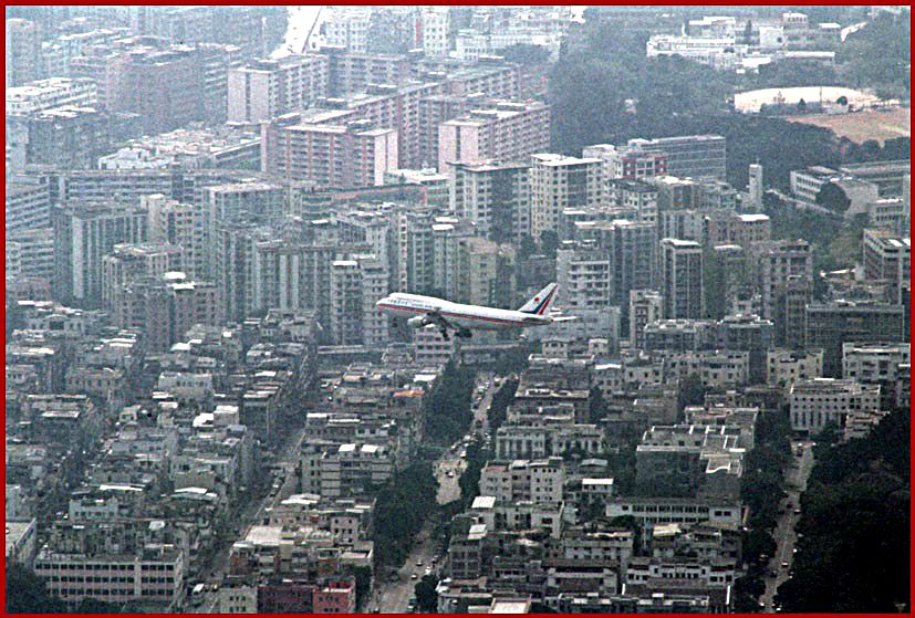 1997-02-036  - View from Lion Rock - a sight we will never see again, - a jumbo jet roaring just above the Kowloon roof tops before landing at Kai Tak - (Photo- and copyright: Karsten Petersen)