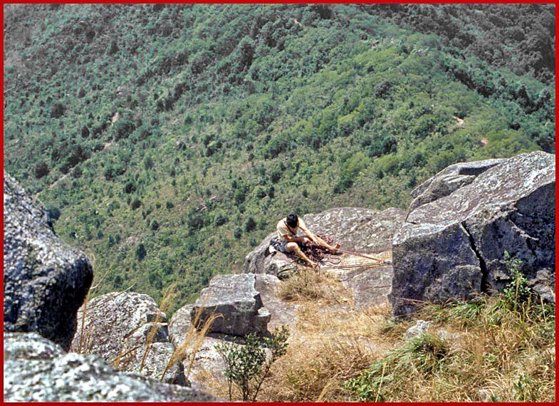 2002-12-076  - Lion Rock - a rock climber taking care of his gear on the very top of the 