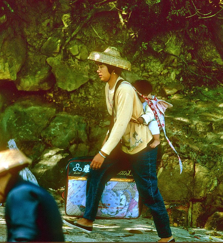 1996-07-030  - An illegal visitor from China,- with a bag of smuggler goods, and baby on her back -