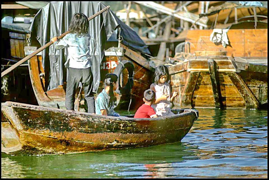 1973-04-053  -  Children skilfully navigating a sampan between the anchored junks, Aberdeen Harbour, - autumn 1973  -  (Photo- and copyright: Karsten Petersen)