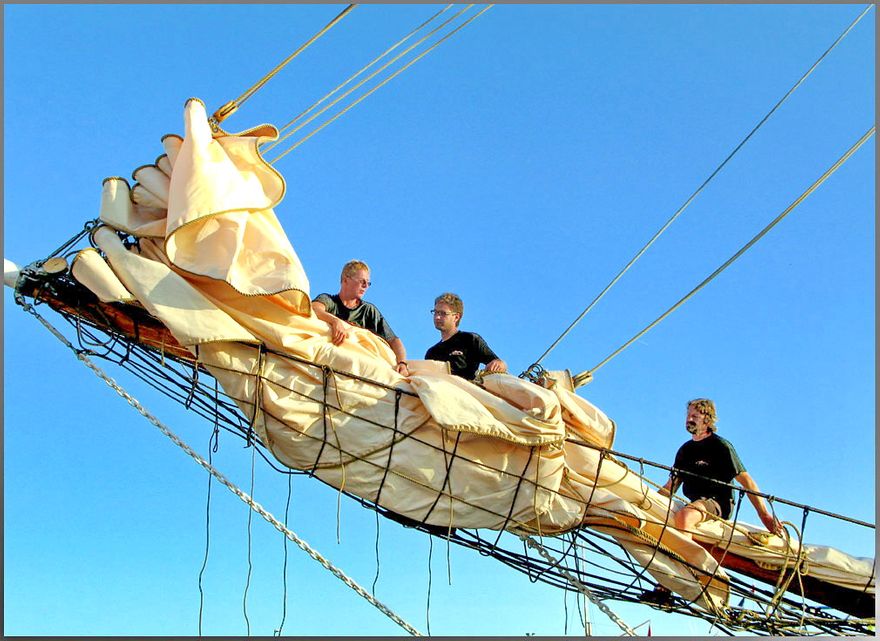 2008-7-23.239  -As the sun sets, - sailors prepare their ship and secure the sails for the night  - (Photo- and copyright: Karsten Petersen )